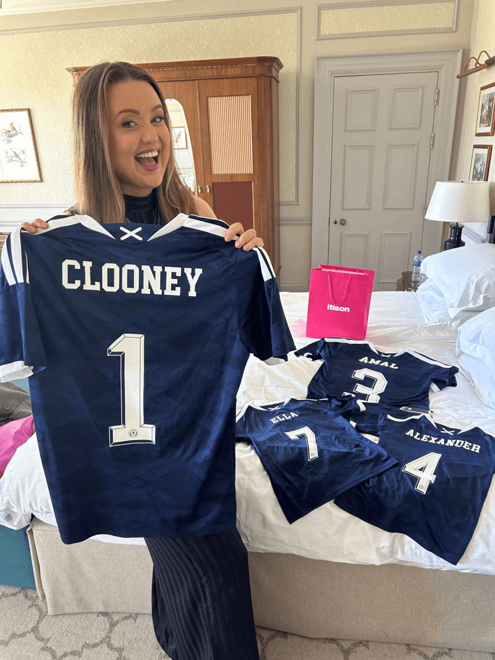 Prize draw winner Claire Phale holds up a Scotland kit with the name Clooney on the back, ahead of gifting it to Hollywood star George Clooney