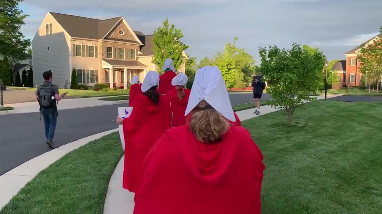 Pro-choice protestors in Handmaids'sTale costumes surround Supreme Court Justice's house