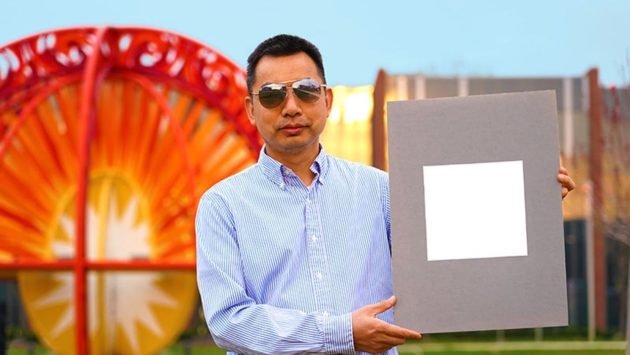 <p>Purdue University professor Xiulin Ruan holds up a sample of the whitest paint on record</p>