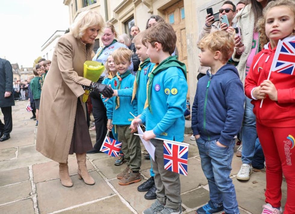 Queen Camilla shakes hands with a young well-wisher during her visit to The Poppy Project, a display of knitted and crocheted poppies created to mark the 80th anniversary of the end of the Second World War, at St Bartholomew\u2019s Church in Corsham, Wiltshire