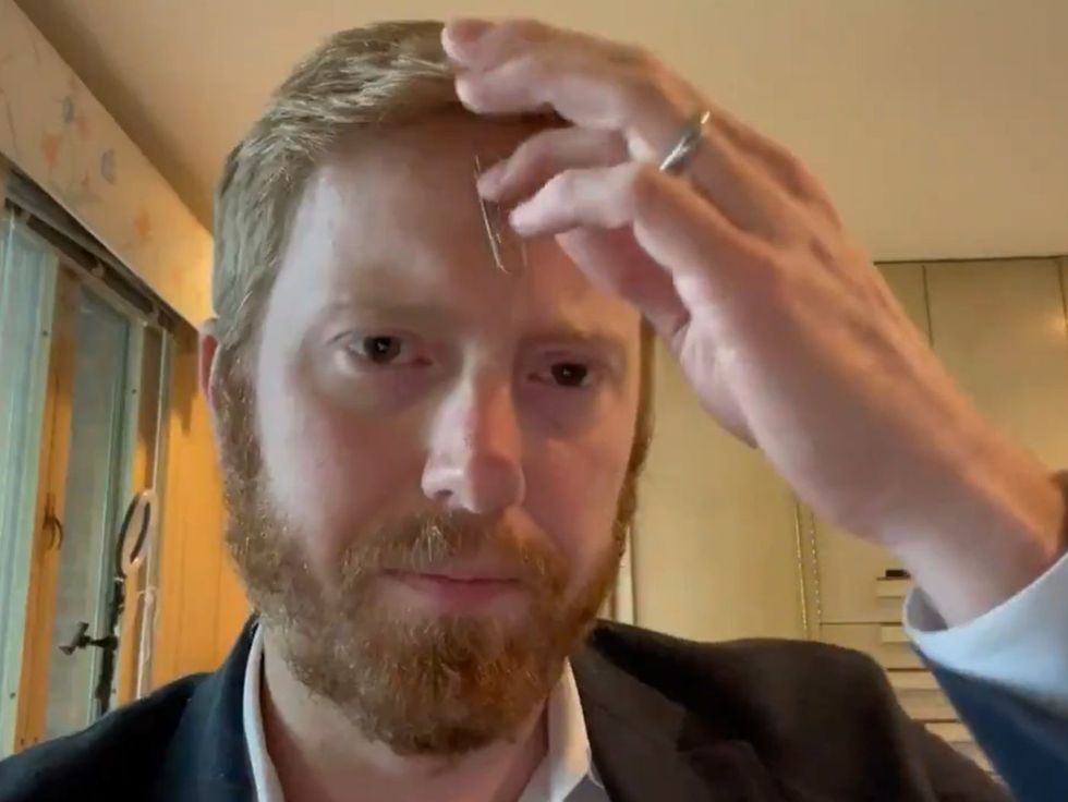 <p>Republican congressman, Peter Meijer holds the paper clip to his head to debunk vaccine conspiracy theory</p>