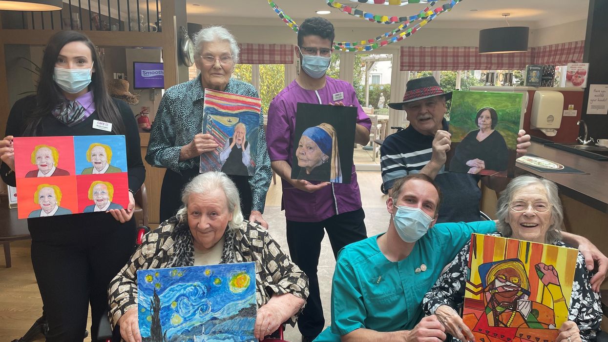 Residents and staff from Sandfields Care Home in Cheltenham pose with their artworks (Care UK/PA)