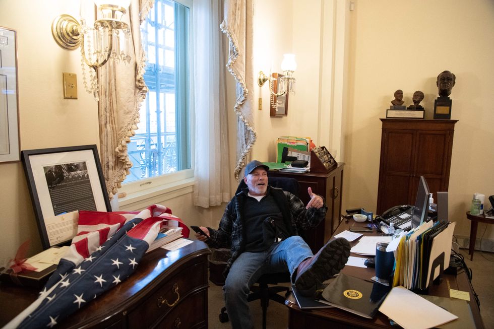 Richard Barnett, a supporter of US President Donald Trump sits inside the office of US Speaker of the House Nancy Pelosi. (Photo by SAUL LOEB/AFP via Getty Images)