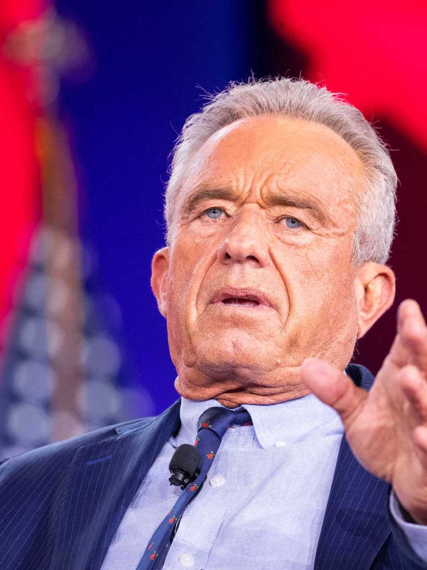 Robert F Kennedy Jr, a white man with short grey hair and a blue suit, speaking at CPAC in Texas.