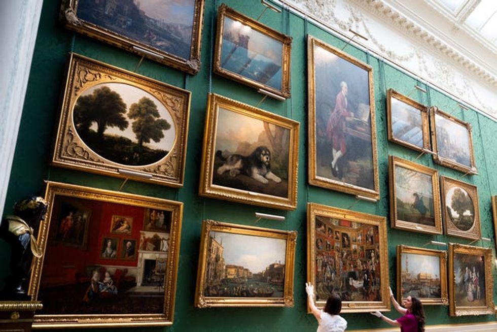 Royal Collection Trust staff adjust Johan Joseph Zoffany's The Tribuna of the Uffizi in the new display in the Picture Gallery at Buckingham Palace