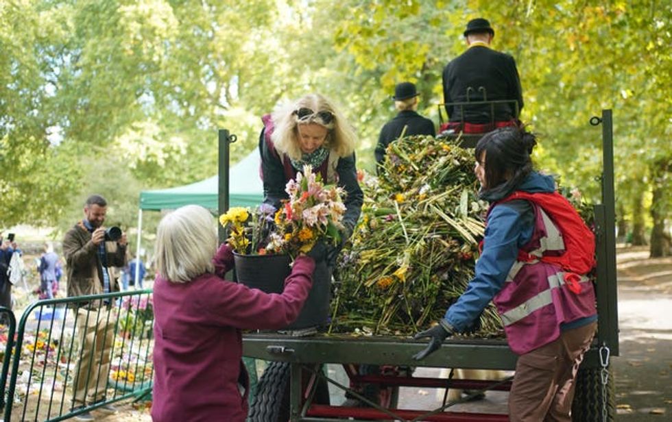Royal Parks staff and volunteers remove floral tributes from Green Park