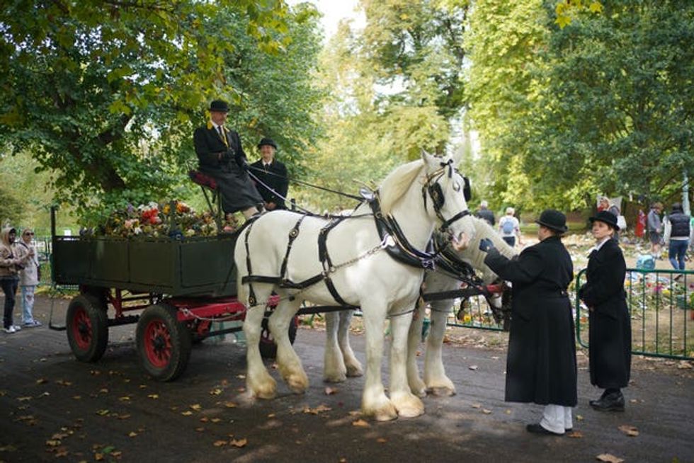 Royal Parks staff and volunteers remove floral tributes from Green Park