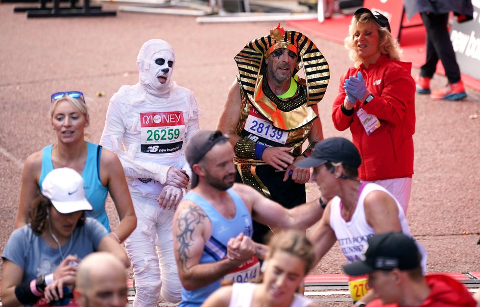 Runners in fancy dress after finishing the Virgin Money London Marathon (Yui Mok/PA)