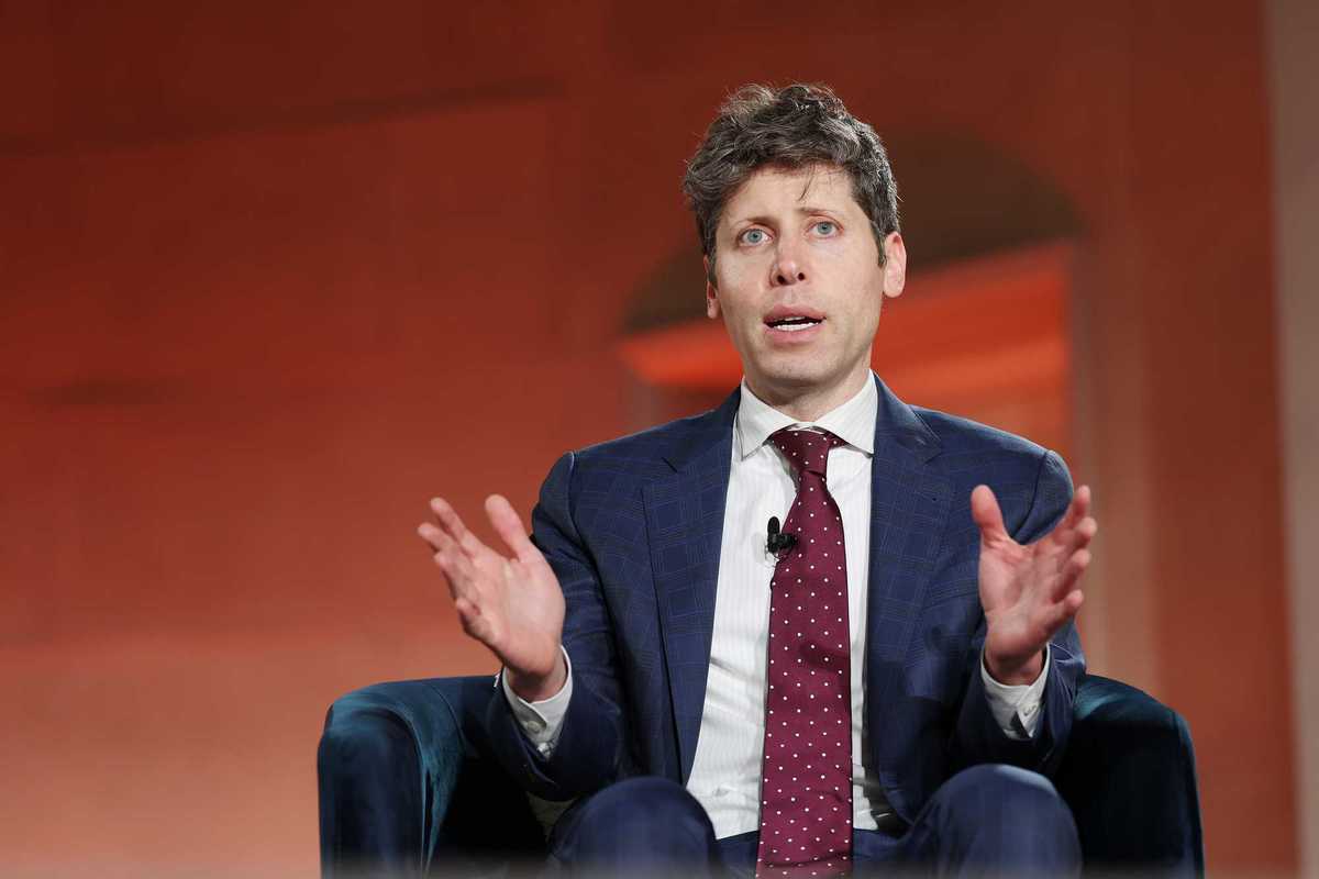Sam Altman sitting on a black chair and speaking at the BlackRock US Infrastructure Summit.
