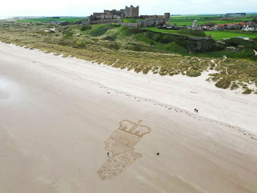 Sand artist Claire Eason from Sunderland puts the finishing touches to her 90 ft by 65ft sand sculpture of King Charles III on Bamburgh beach in Northumberland to mark the celebrations of King Charles III\u2019s coronation this weekend