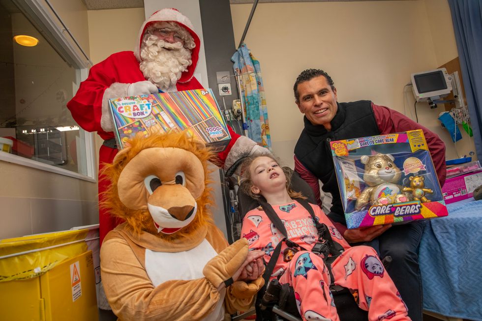 Santa, his lion helper and Sean Og O hAilpin deliver toys to seven-year-old Ciara Murphy, who uses a wheelchair