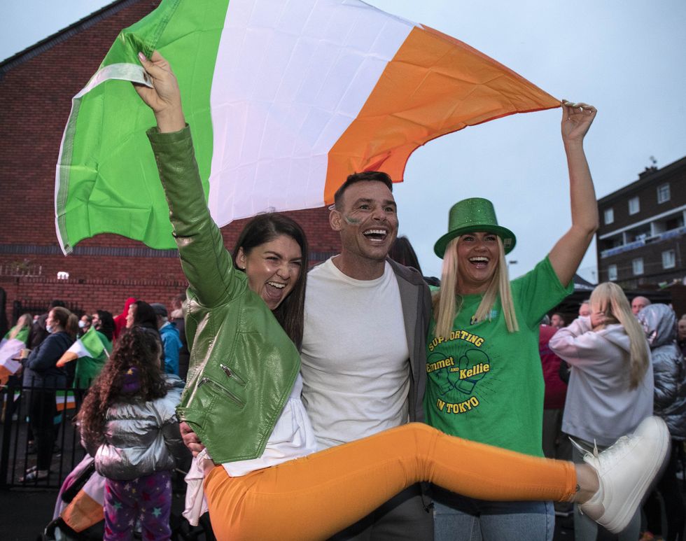 Sarah Dunne, Michael Hanley and Sabrina Dunne join neighbours, family and friends gathered outside the family home of Irish boxer Kellie Harrington in Dublin (Damian Eagers/PA)