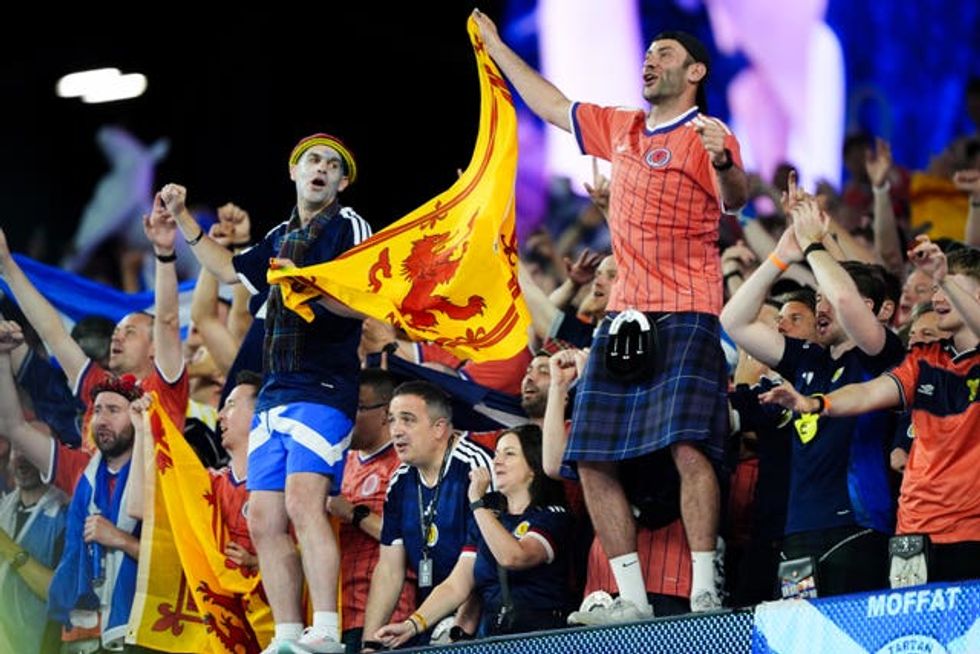 Scotland fans celebrating and holding Scottish flags