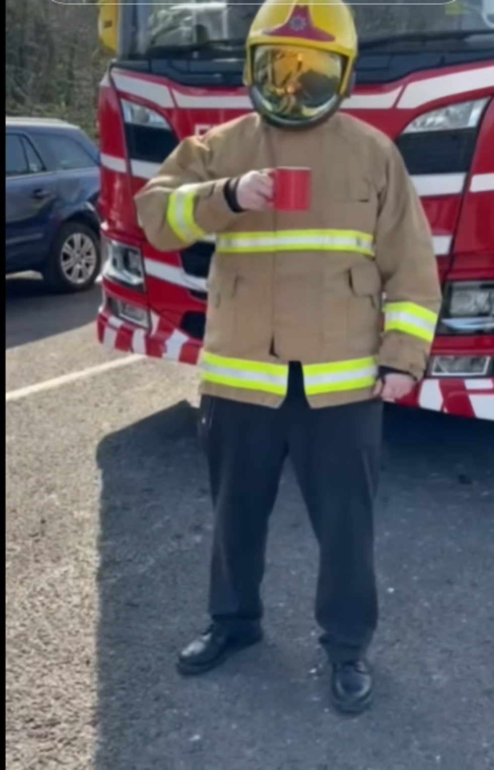 Screenshot from a TikTok video of a firefighter from Cheshire Fire and Rescue Service holding a red mug of tea