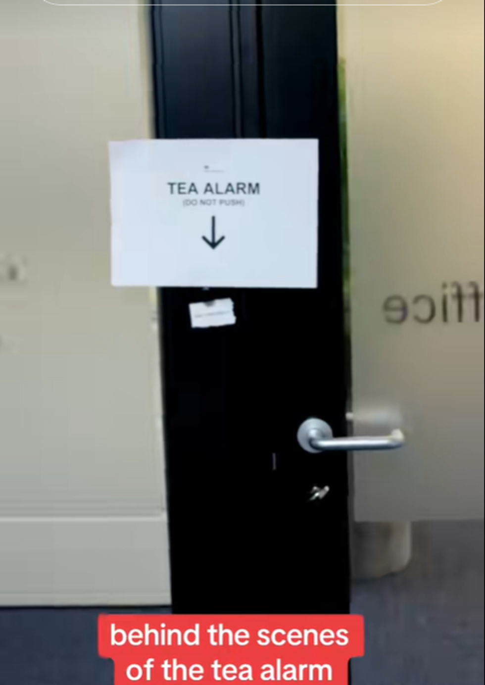 Screenshot from a TikTok video posted by the UK Government of a sign which says 'tea alarm' and an arrow pointing to a button