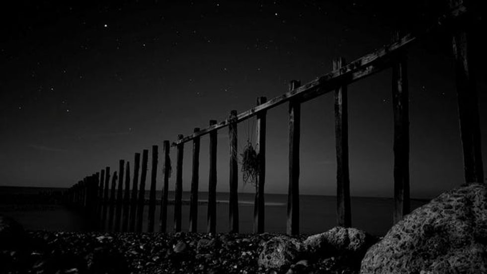 Sea groynes with the moon behind them