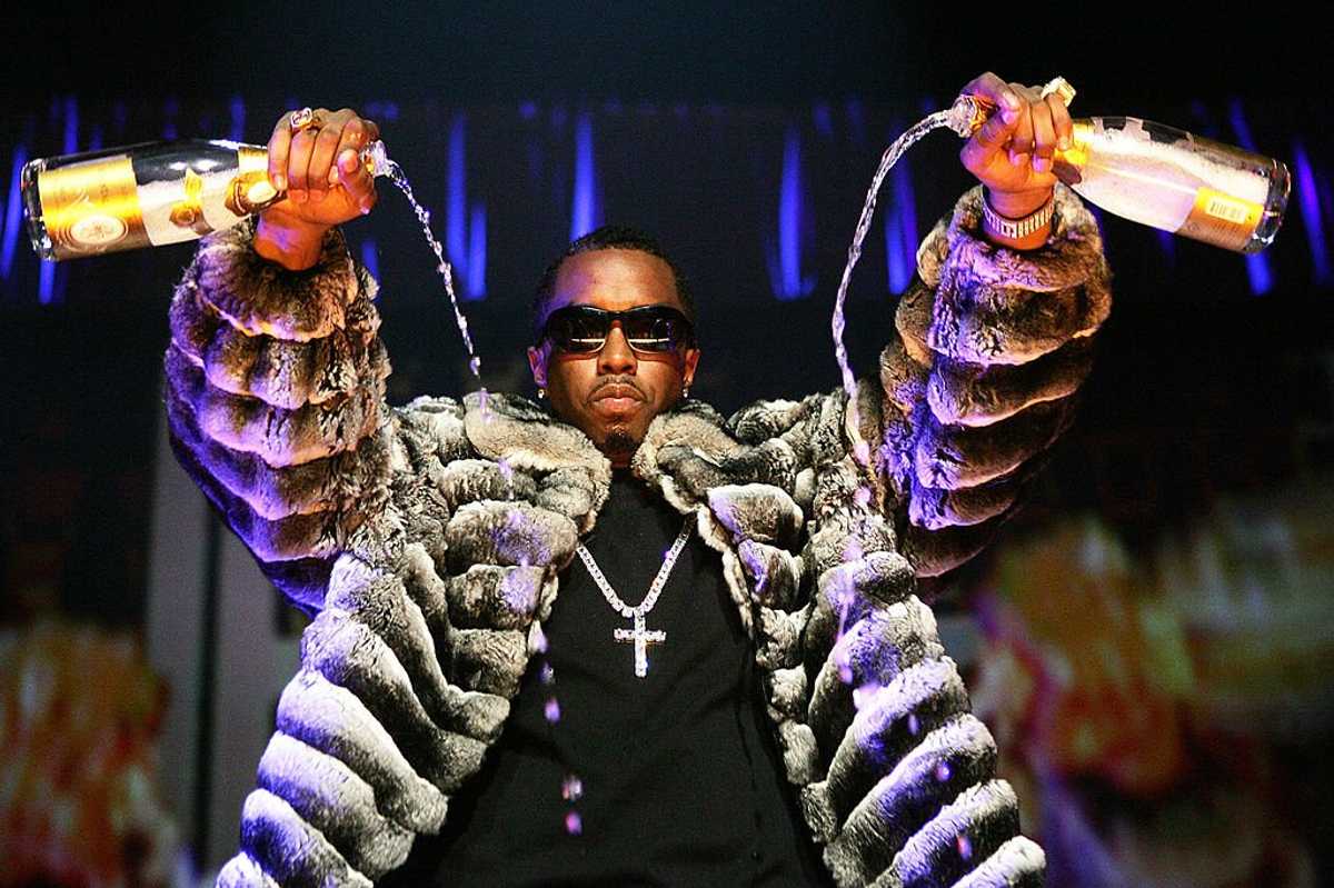 Sean "Diddy" Combs pours two bottles of champagne during a 2005 performance at the Continental Airlines Arena in New Jersey
