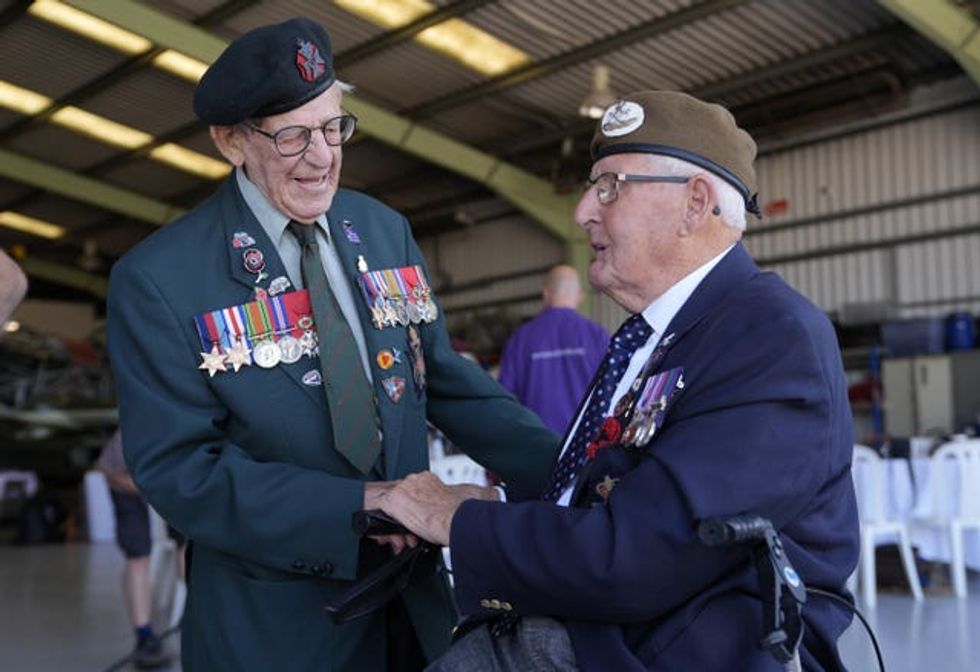 Second World War veterans Paul Terry, 101, (left) and Ivan Staines, 99, greet each other ahead of their flights