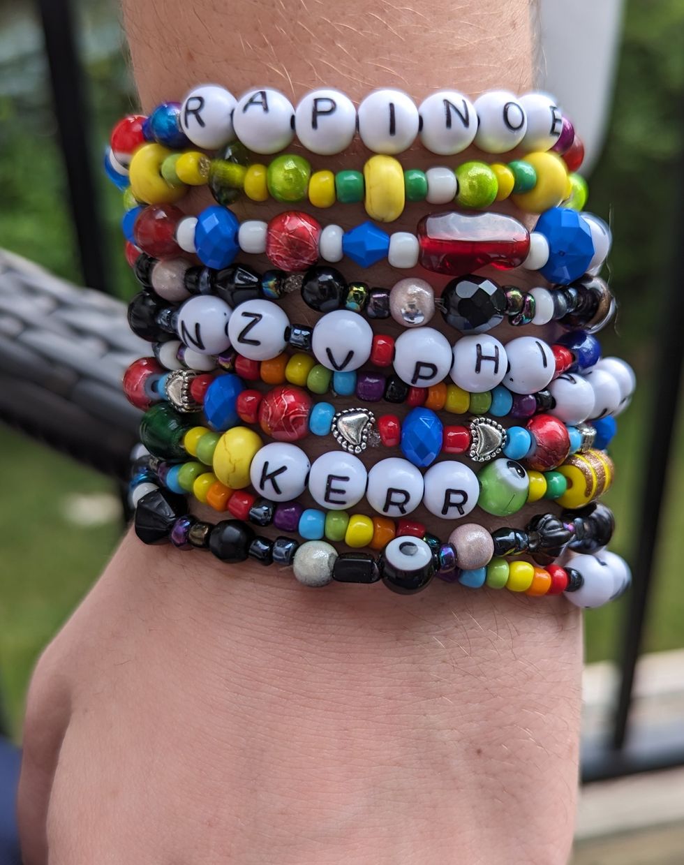 Several handmade bracelets stacked together on a wrist