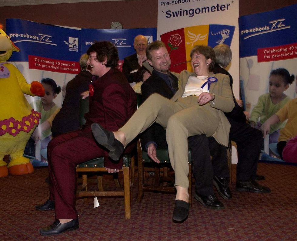 Shadow Education Secretary, Theresa May lands in the lap of Richard Allan, Lib dem MP for Sheffield Hallam as they tussle for a seat during a game of musical chairs.