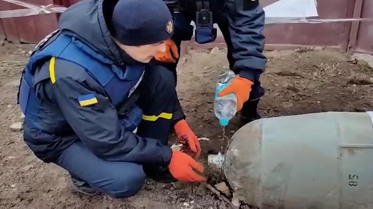 Ukrainians tackle unexploded Russian bomb with bare hands and water bottle