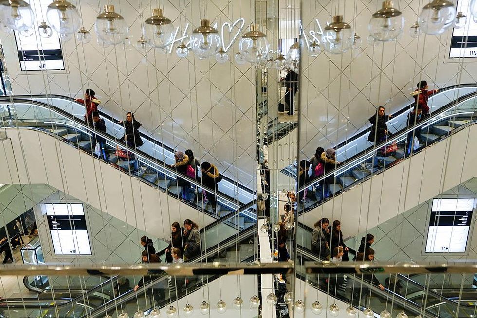 Shoppers ride the escalator inside an H&M retail store during Black Friday events on November 25, 2016 in New York City.