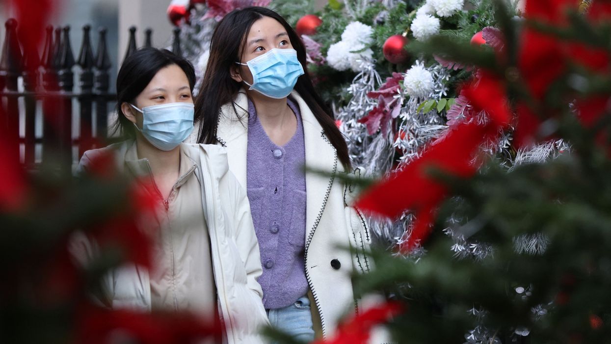 <p>Shoppers wearing face coverings to combat the spread of the coronavirus walk through the Christmas decorations</p>