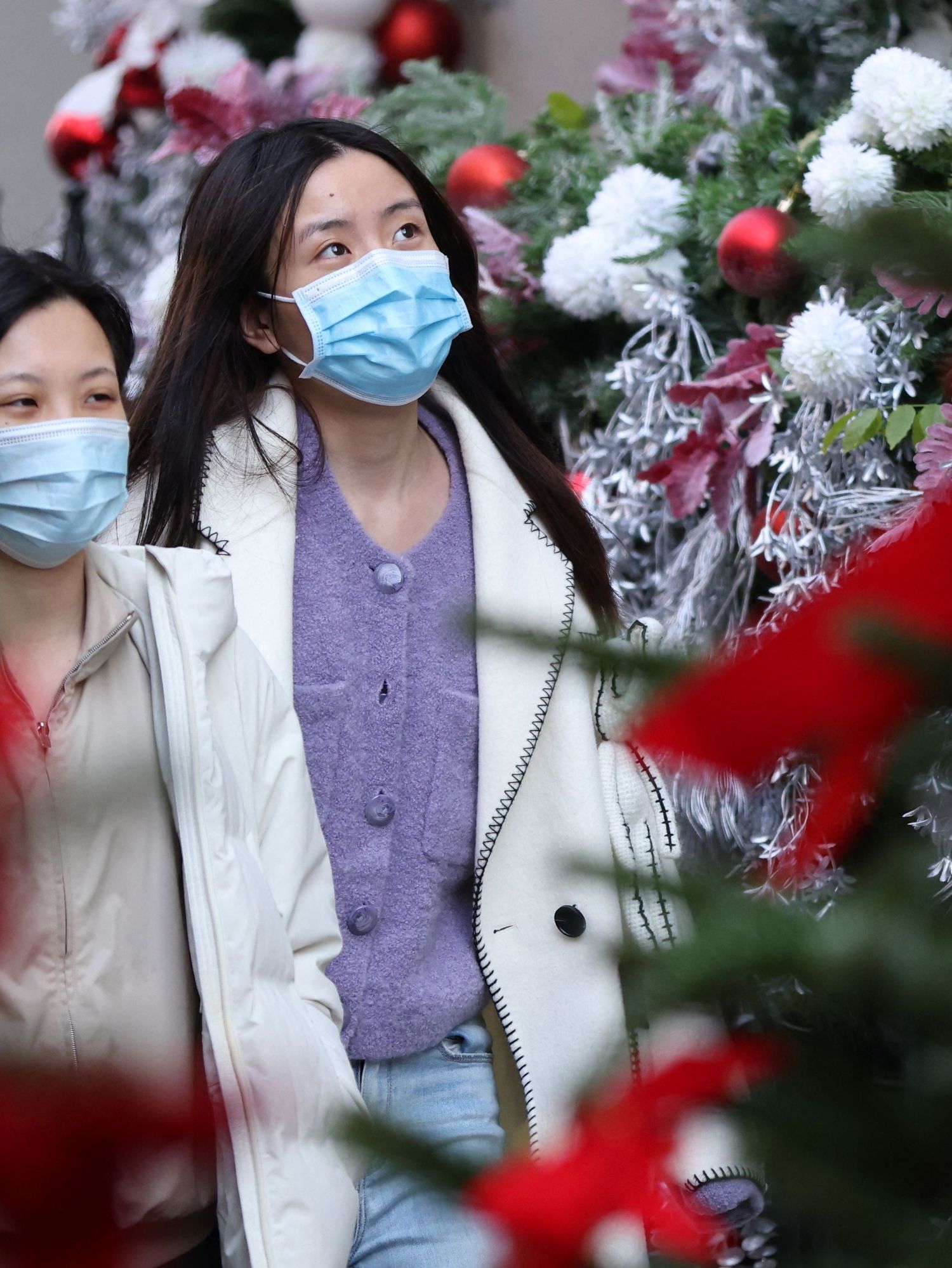 <p>Shoppers wearing face coverings to combat the spread of the coronavirus walk through the Christmas decorations</p>