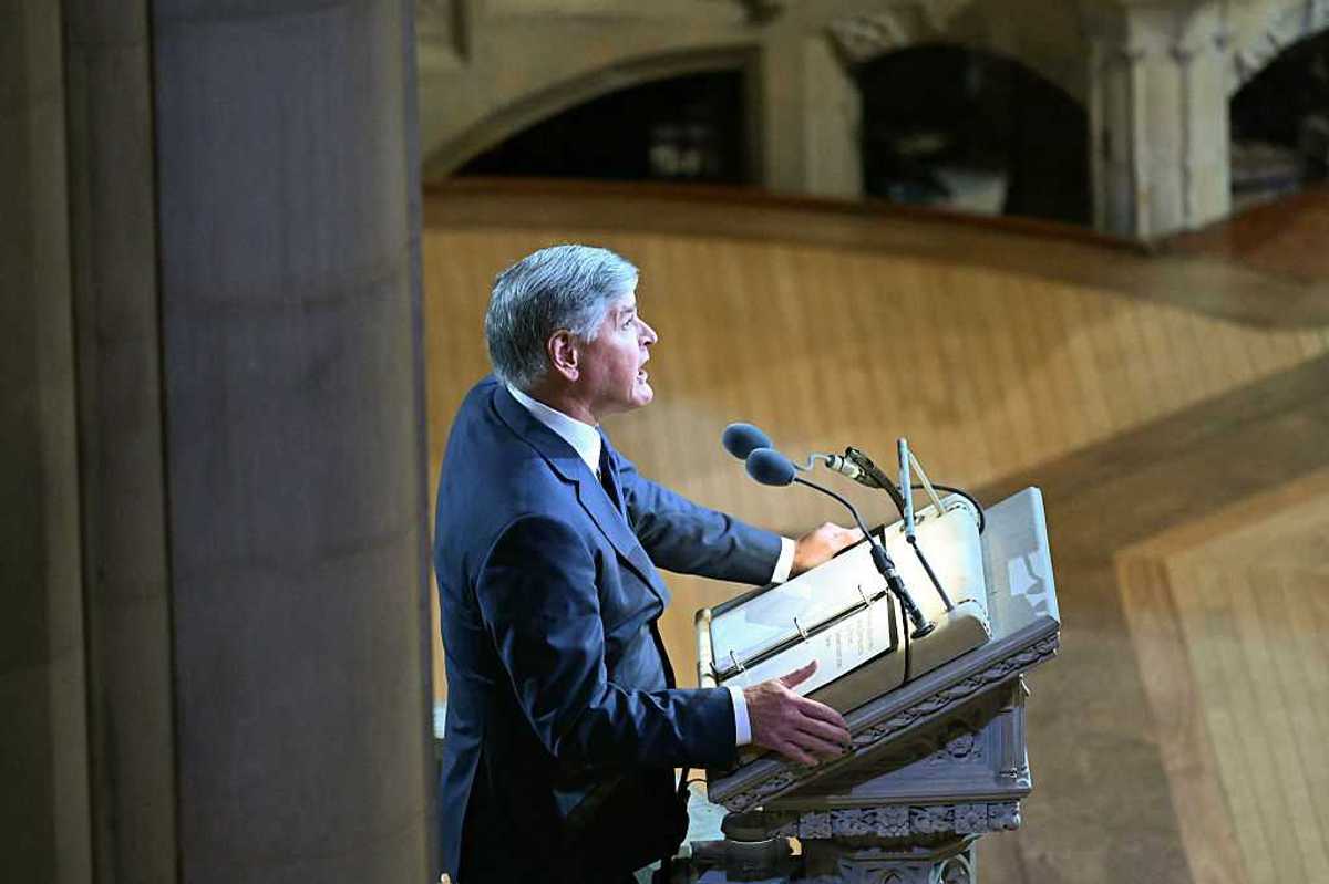 Side-on photo of Sean Hannity speaking behind a lectern at Lindsey Graham's funeral.