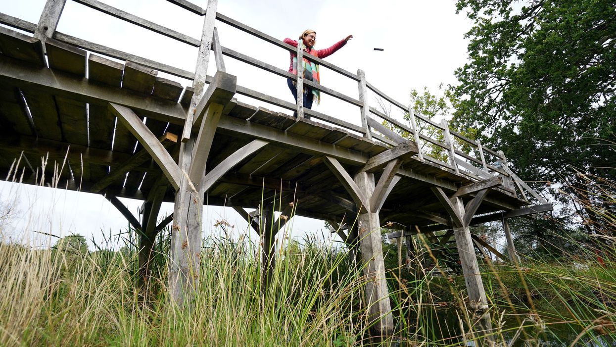 Silke Lohmann of Summers Place Auctions stands on the original Poohsticks Bridge from Ashdown Forest (Gareth Fuller/PA)