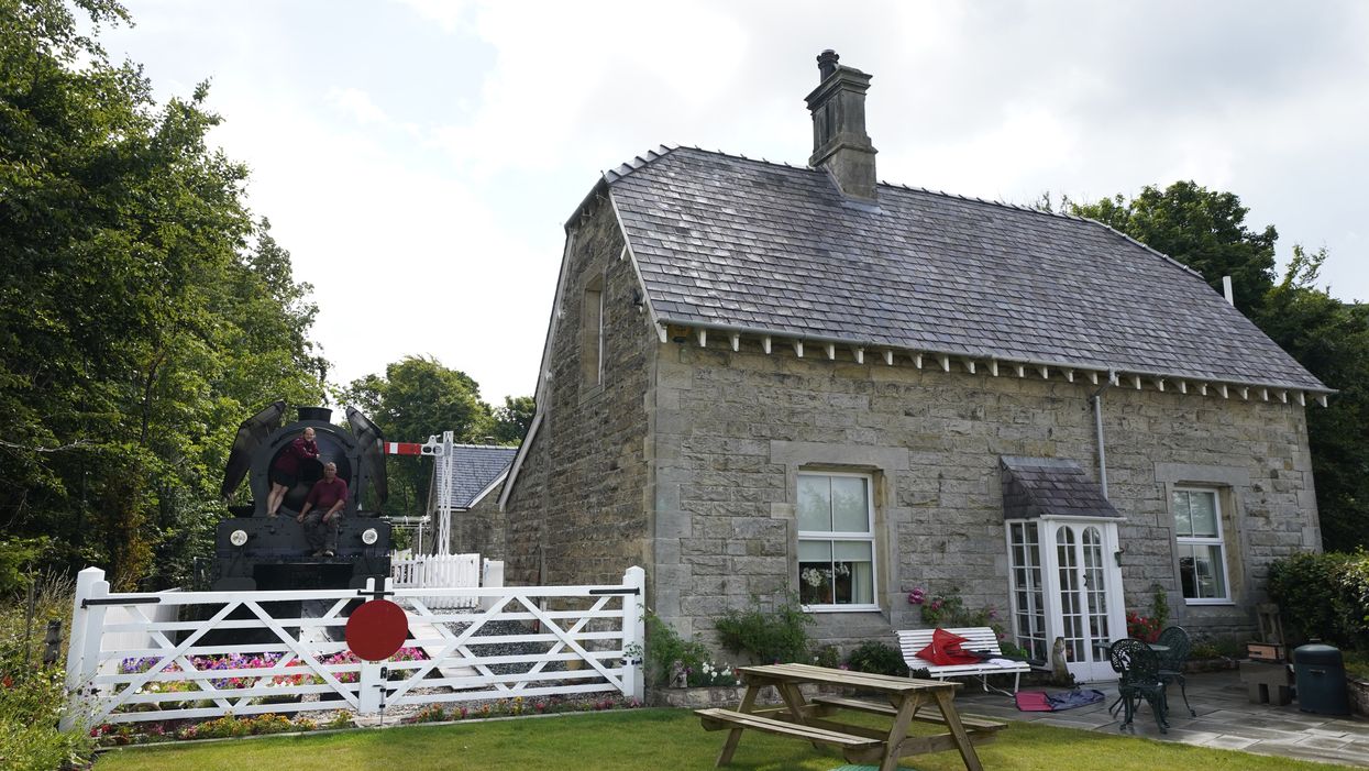 Simon and Diana Parums with their full-size steam train with carriages, tracks and platform as they converted and restored Bassenthwaite Lake station in Keswick (Owen Humphreys/PA)