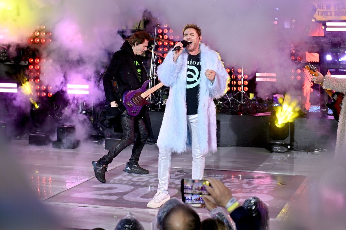 Simon Le Bon wears a blue fur coat as he performs on stage