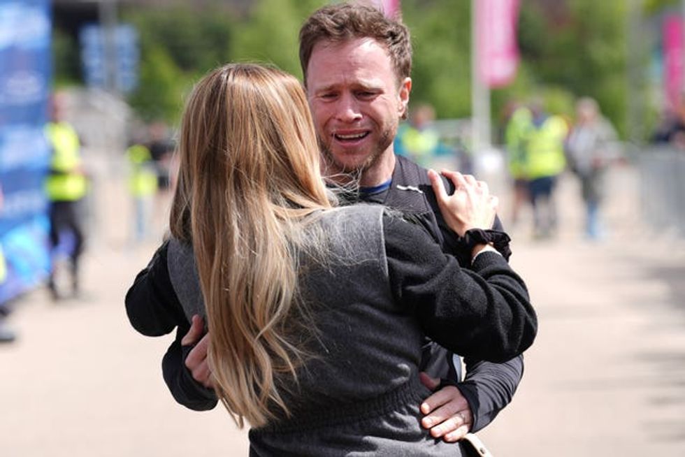 Singer Olly Murs hugs wife Amelia as he crosses the finish line for \u2018Olly Murs: Into The Unknown\u2019, after a five-day 400km challenge in which he tackled some of the UK\u2019s most demanding terrain by running, rowing and riding from Manchester United\u2019s Old Trafford stadium in Salford, to the London Stadium, east London, marking Soccer Aid for Unicef\u2019s 20th anniversary