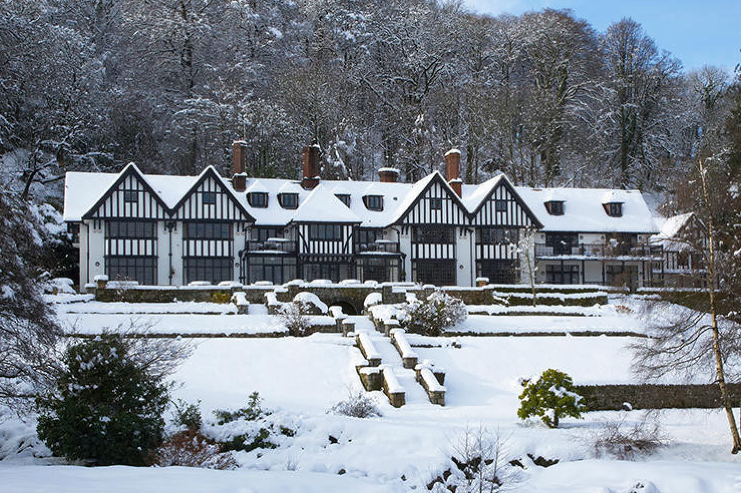 Snow covers the exterior of an old Tudor building