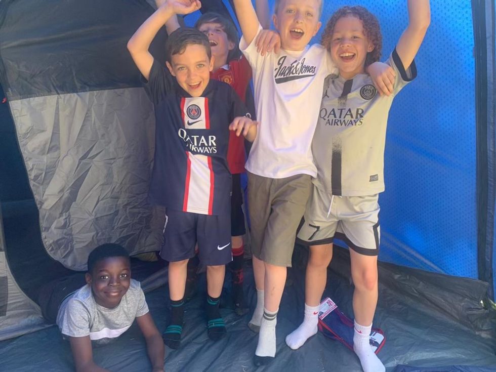 Some of the boys standing in a tent smiling at the camera