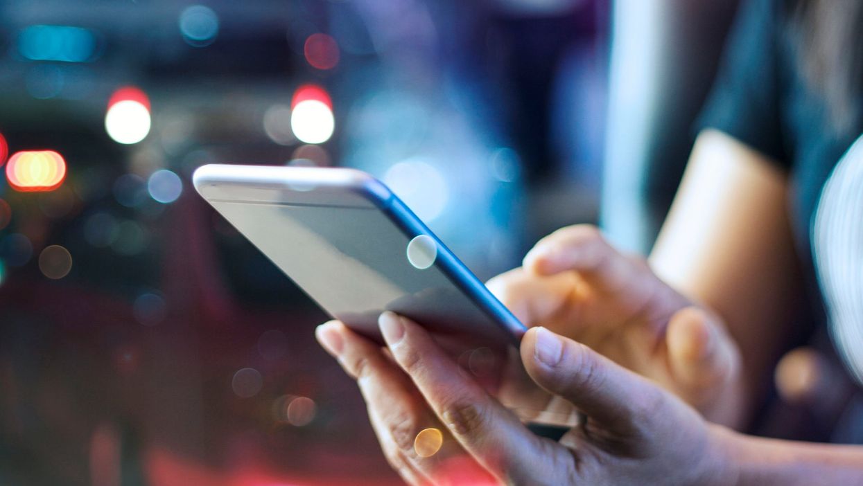 <p>Someone using their phone at night</p>