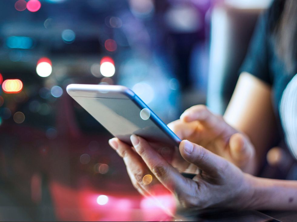 <p>Someone using their phone at night</p>