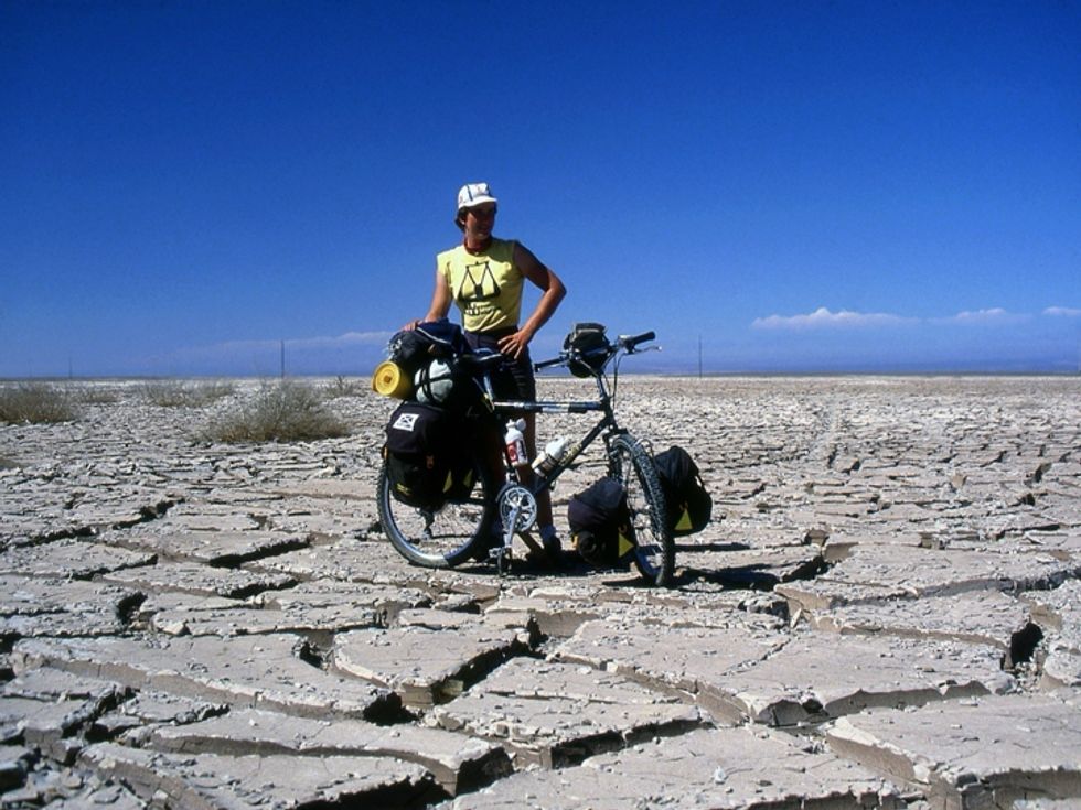 Sophie Trafford posing next to her bike, which is laden down with luggage, in 1985