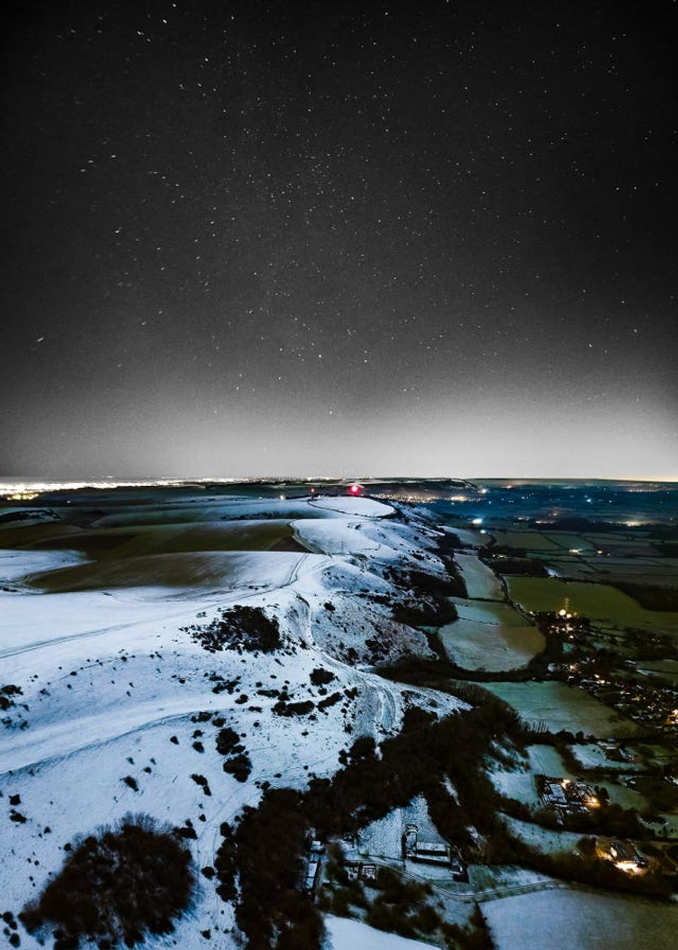 Starry sky above snow-covered downs seen from the air