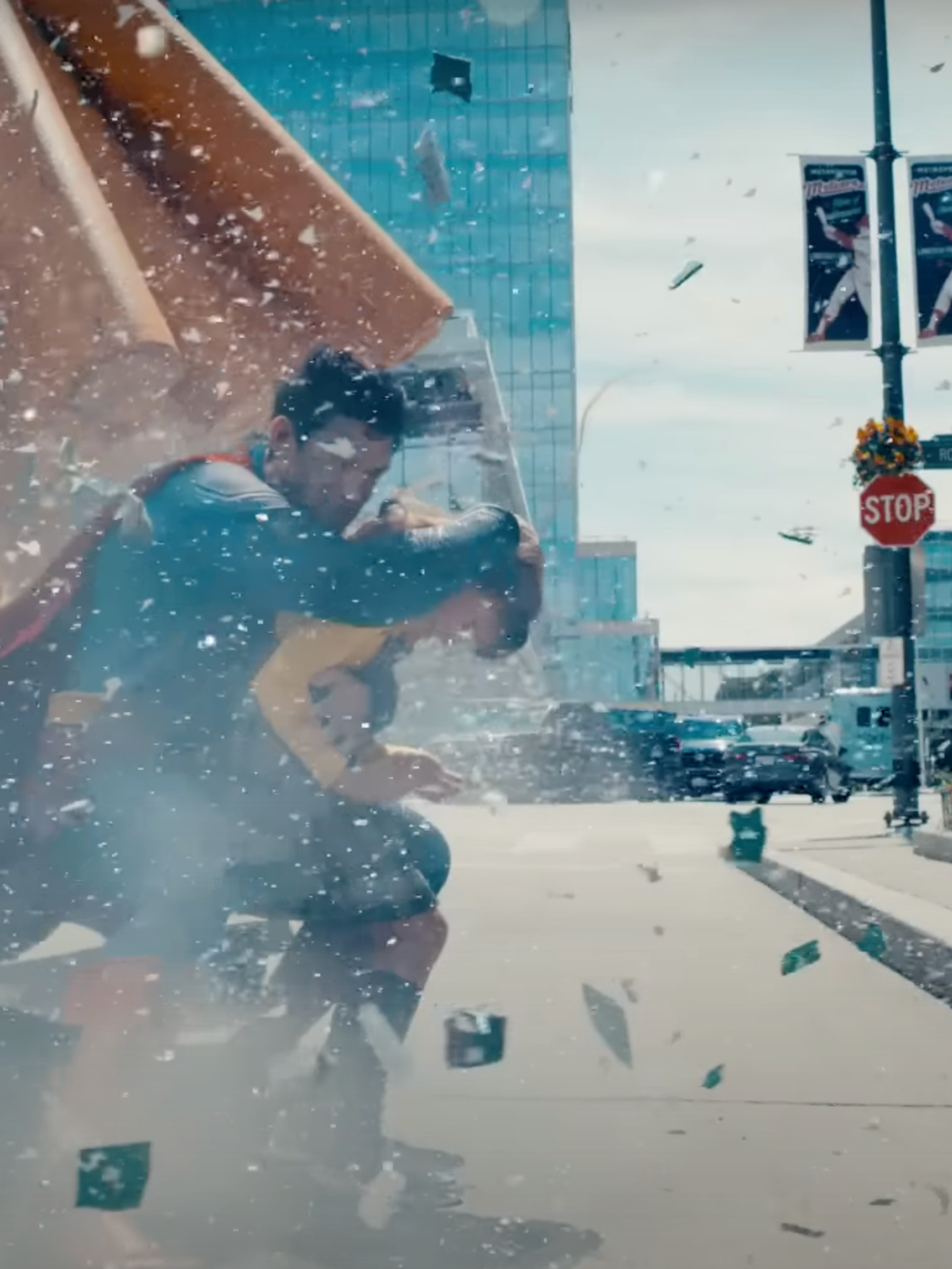Superman shields a young girl from flying debris.