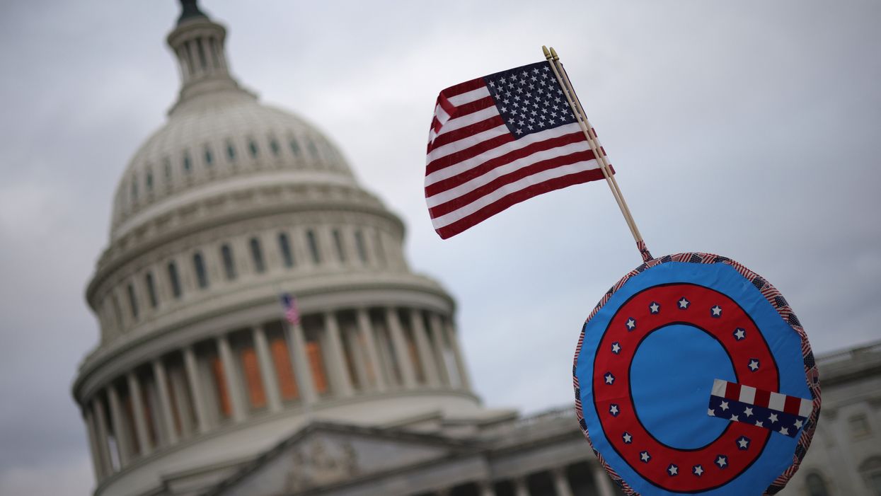 Supporters of Donald Trump fly a US flag with a symbol from the group QAnon as they gather outside the US Capitol on 6 January 2021 in Washington, DC