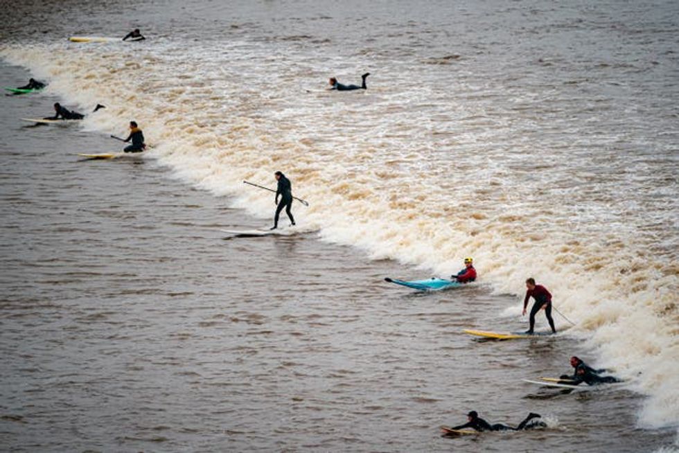 Surfers ride the first five-star Severn Bore of 2024 at Newnham