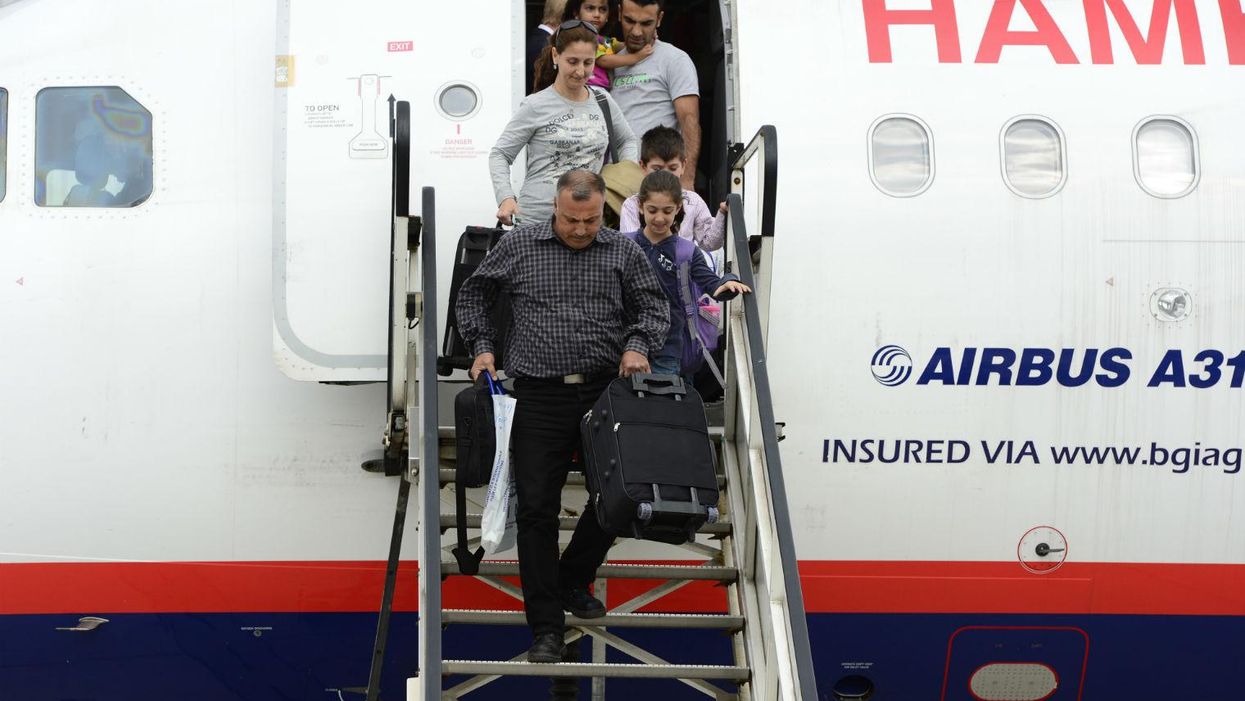 Syrian refugees leave an airplane on the airport in Hanover, central Germany on September 11, 2013