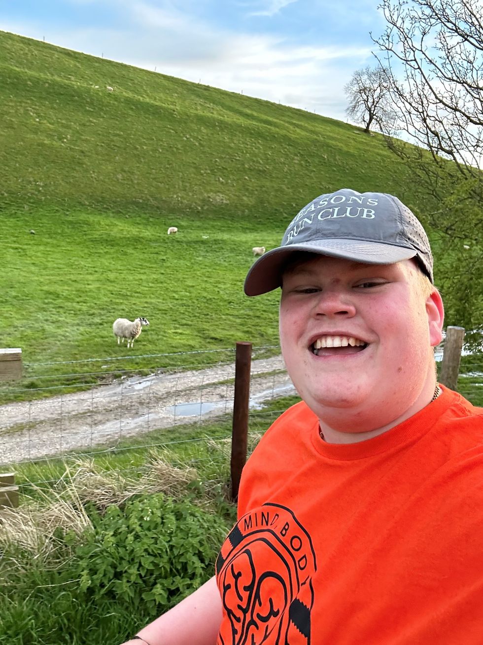 Teenage taking selfie with sheep in the background