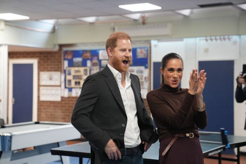 The Duke and Duchess of Sussex cheer and applaud during a visit to Epic Partners in Nottingham