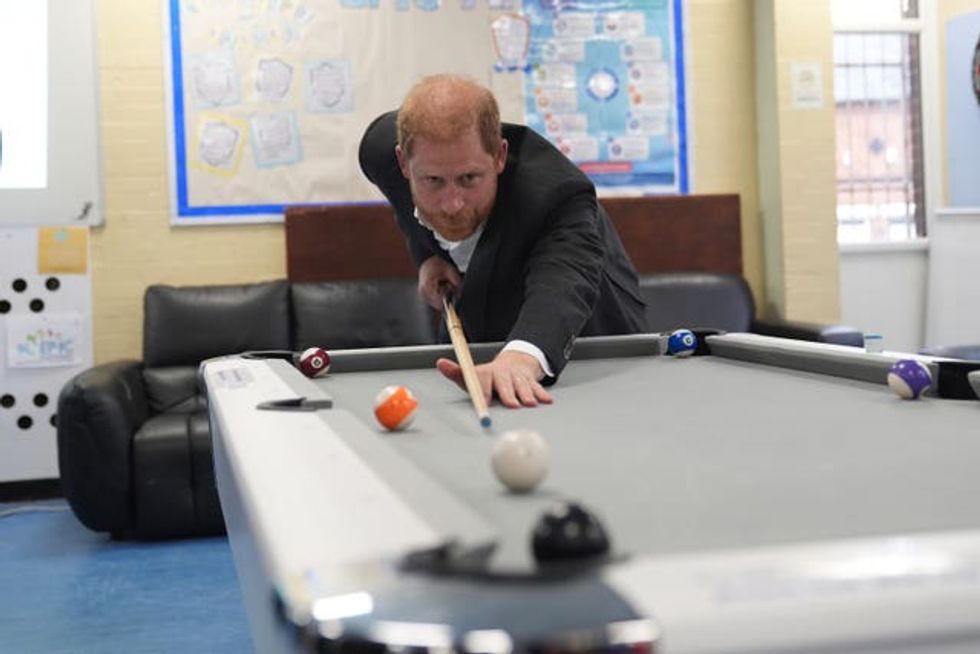 The Duke of Sussex plays pool during a visit to Epic Partners in Nottingham.