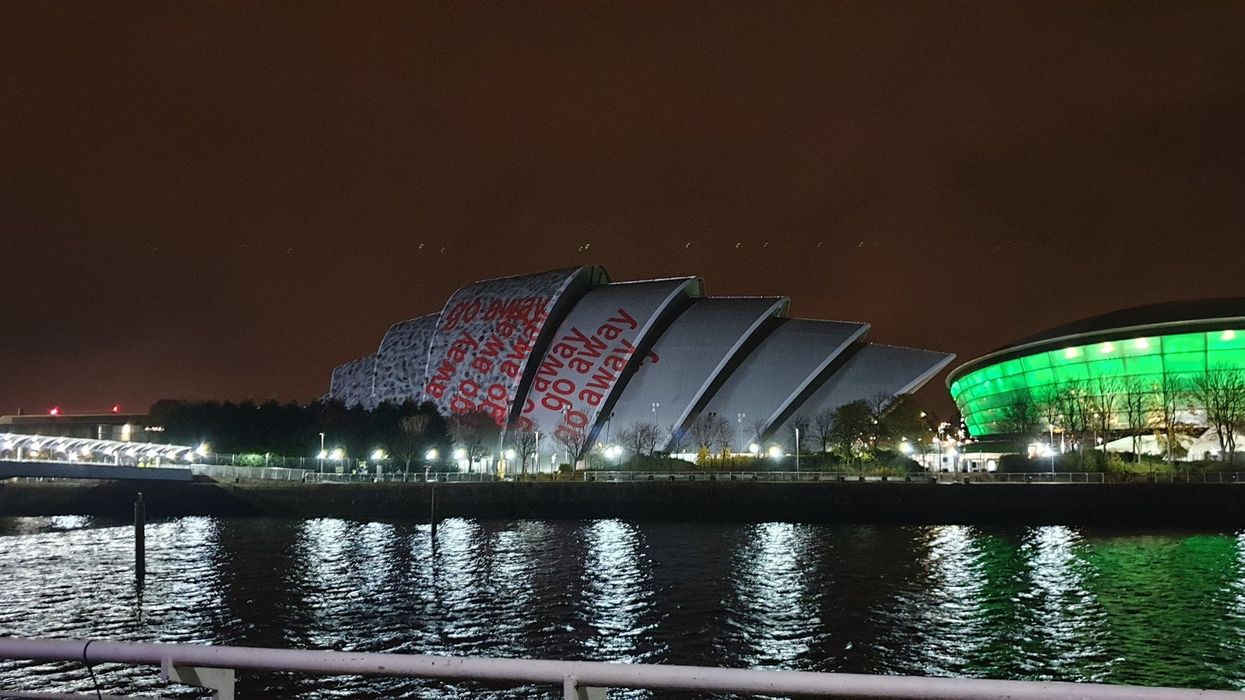 The ‘go away’ projections on the Cop26 conference centre (Graeme Eddolls/PA)