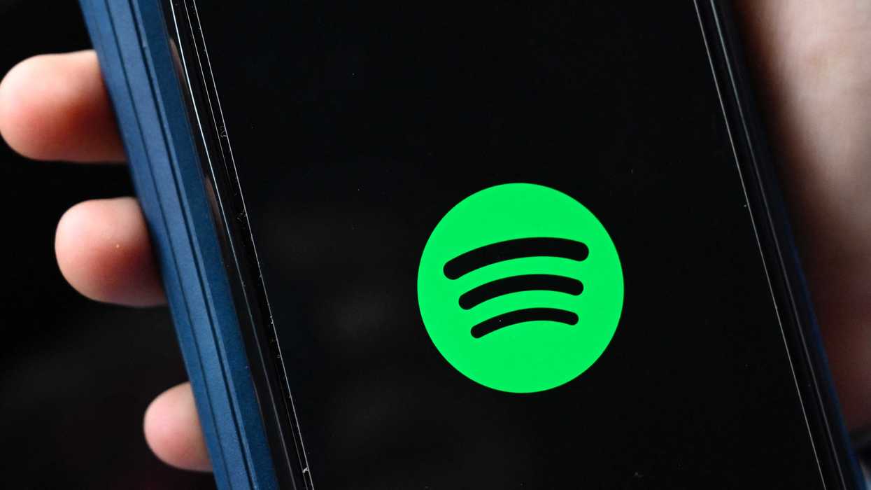 The green Spotify logo on an iPhone screen.