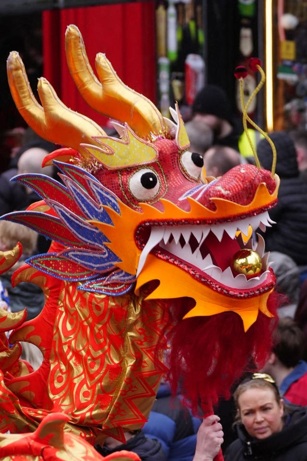 The head of an orange dragon is paraded as part of the celebration