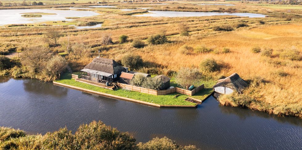 The Holt building seen from above near a river in the Norfolk Broads